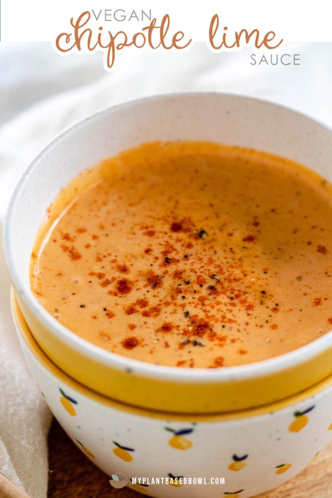 A bowl with an orange sauce and paprika sprinkled on top.