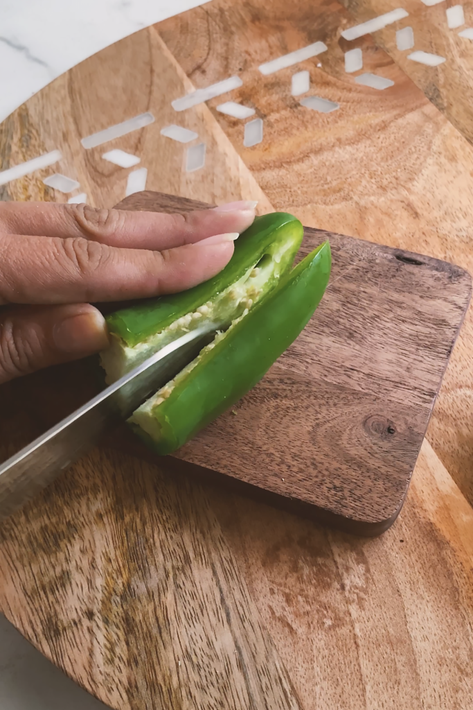 Cutting a jalapeno in half.