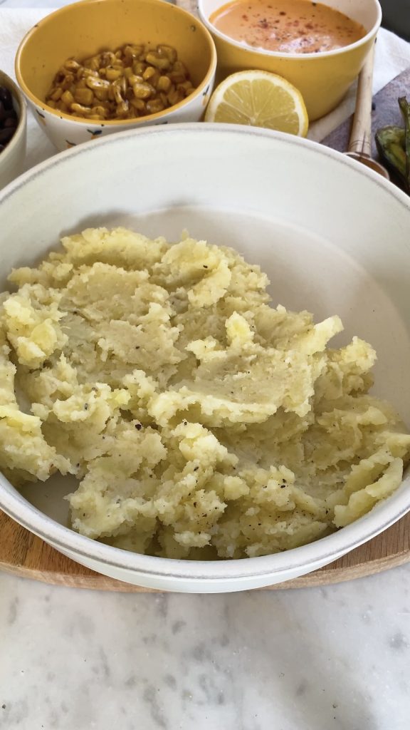 Mashed potatoes on one half of a bowl.