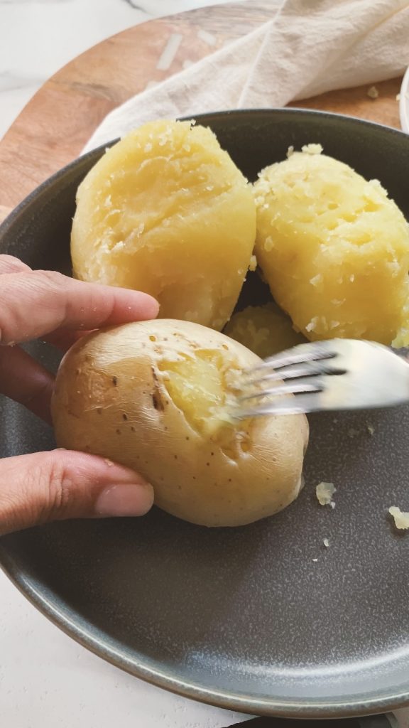 Peeling the skin off of potatoes with a fork.