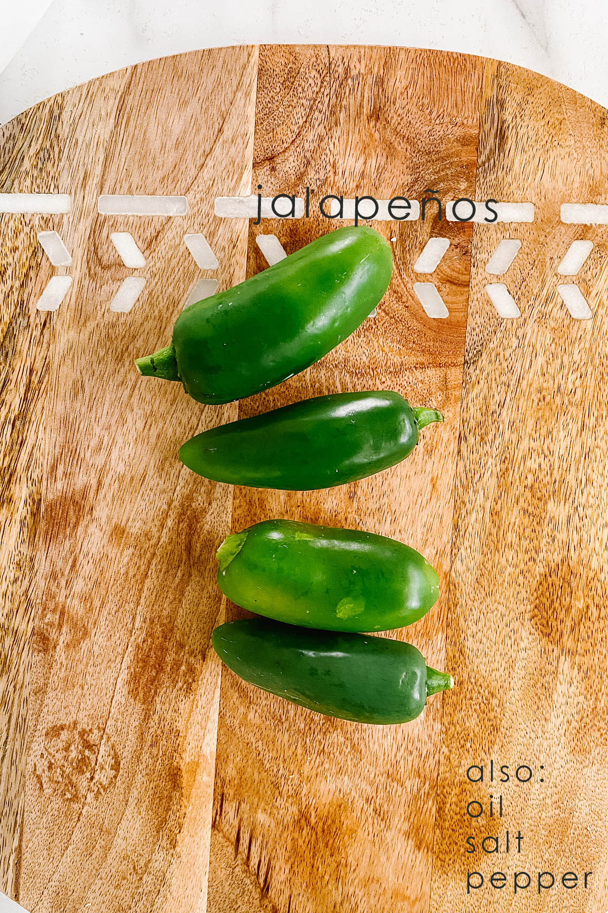 Jalapenos on a wooden cutting board.