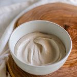 A white cashew sauce in a white bowl with text for Pinterest.