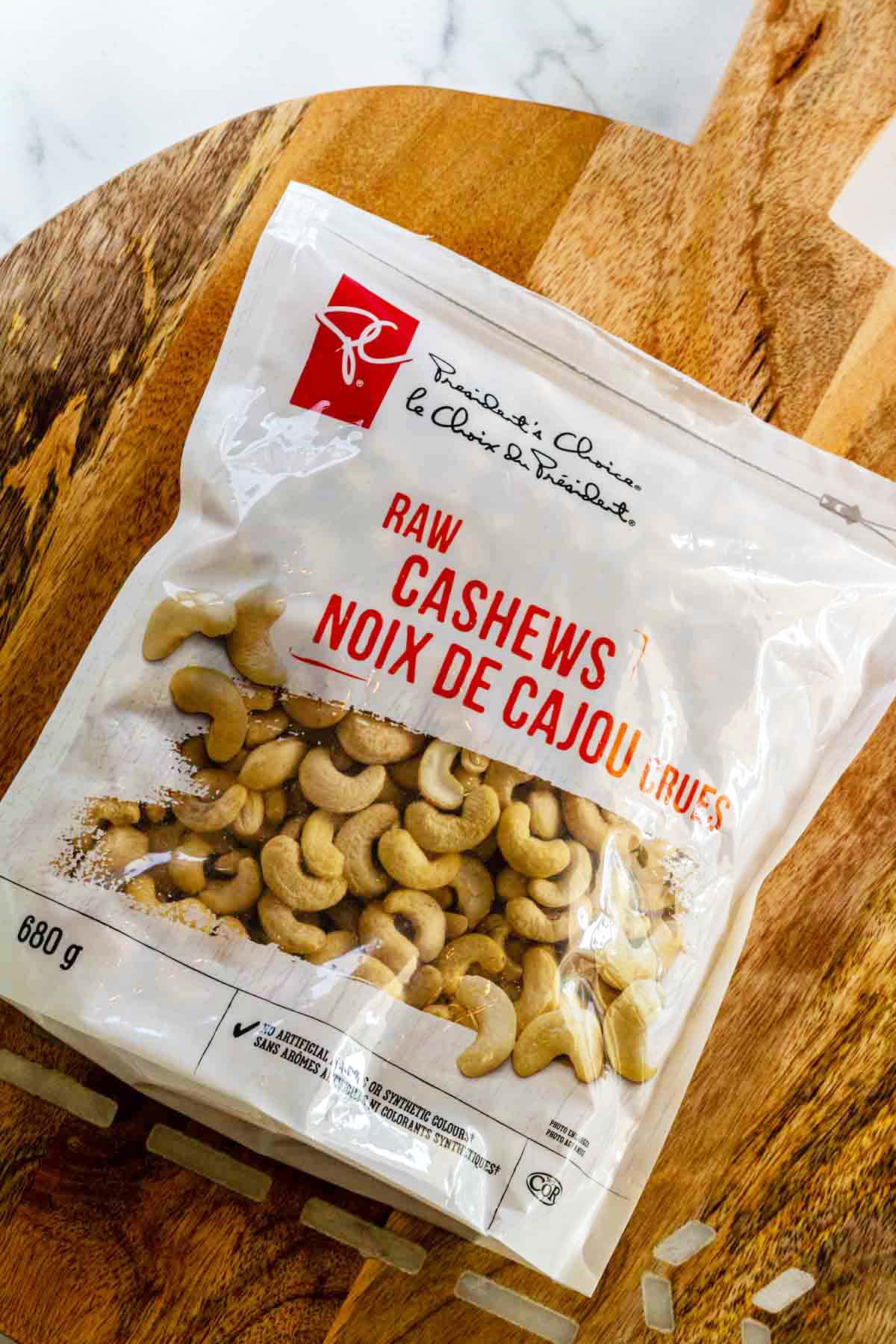 A bag of cashews on a cutting board.