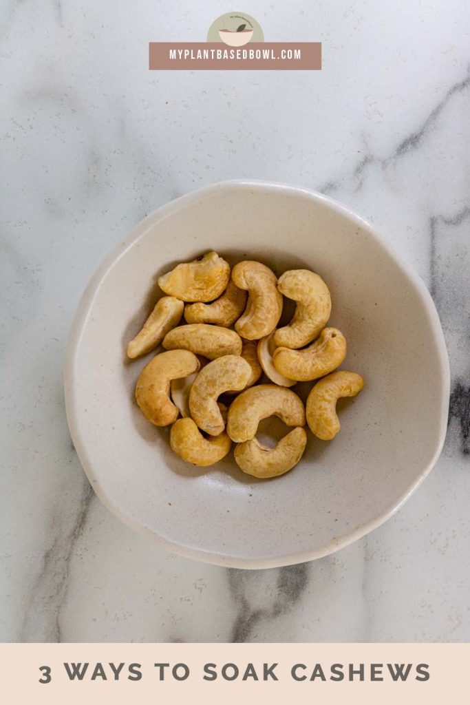 Cashews in a white bowl with a text title for Pinterest.