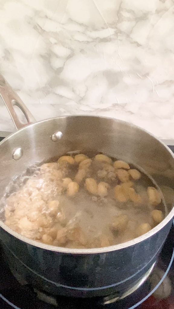 A pot of cashews in water is boiled.