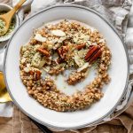 A bowl of buckwheat served like porridge with pecans, hemp seeds, almonds, and milk.