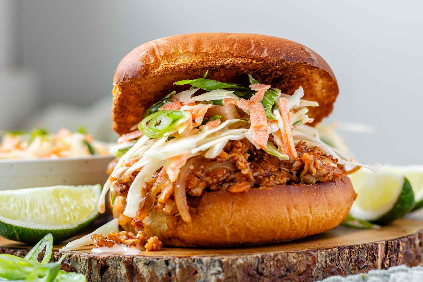 A toasted bun with tofu in barbecue sauce and cabbage salad.