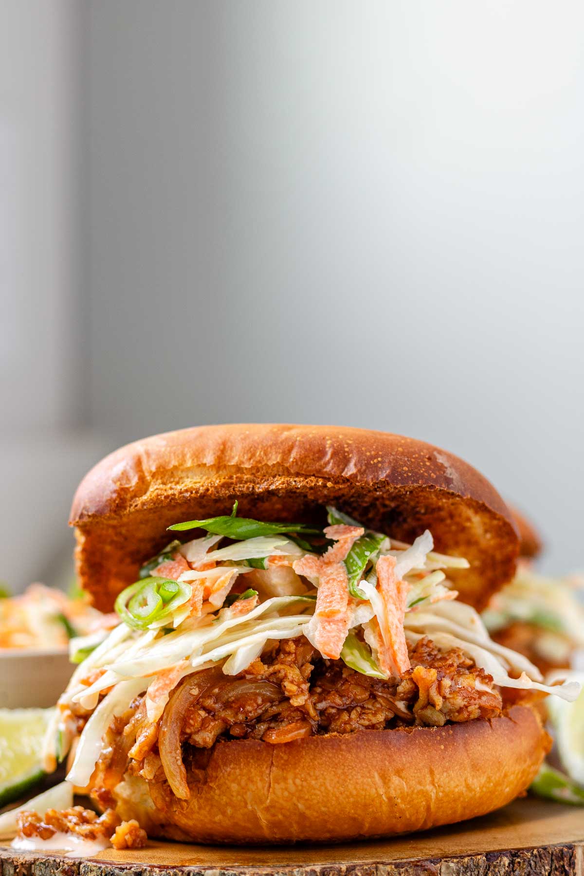A toasted bun with tofu in barbecue sauce and cabbage salad.