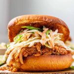 A toasted bun with tofu in barbecue sauce and cabbage salad.