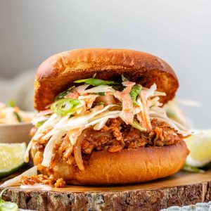 A toasted bun with tofu in barbecue sauce and cabbage salad.