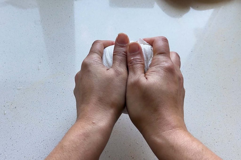 Tofu in paper towel scrunched by hand.