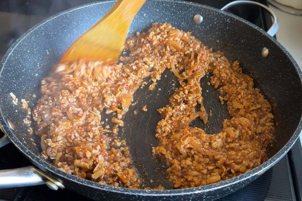 Grated tofu in BBQ sauce in a skillet.