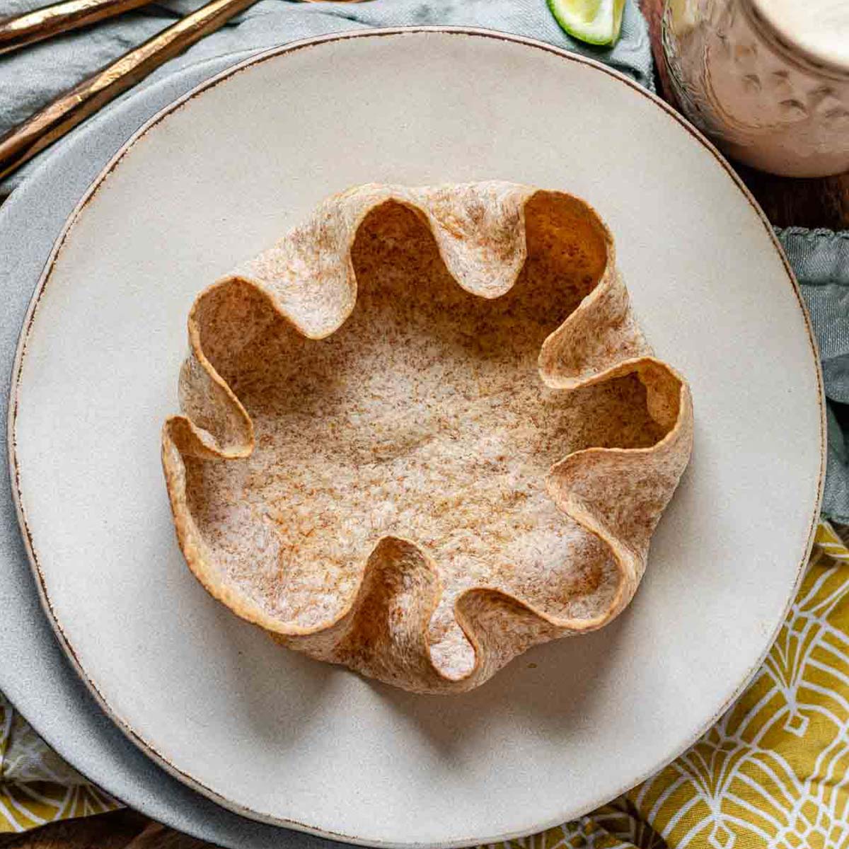 A whole wheat tortilla salad bowl on a plate.