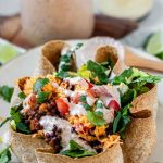 Taco salad in a tortilla bowl with the text black lentil taco salad bowls.