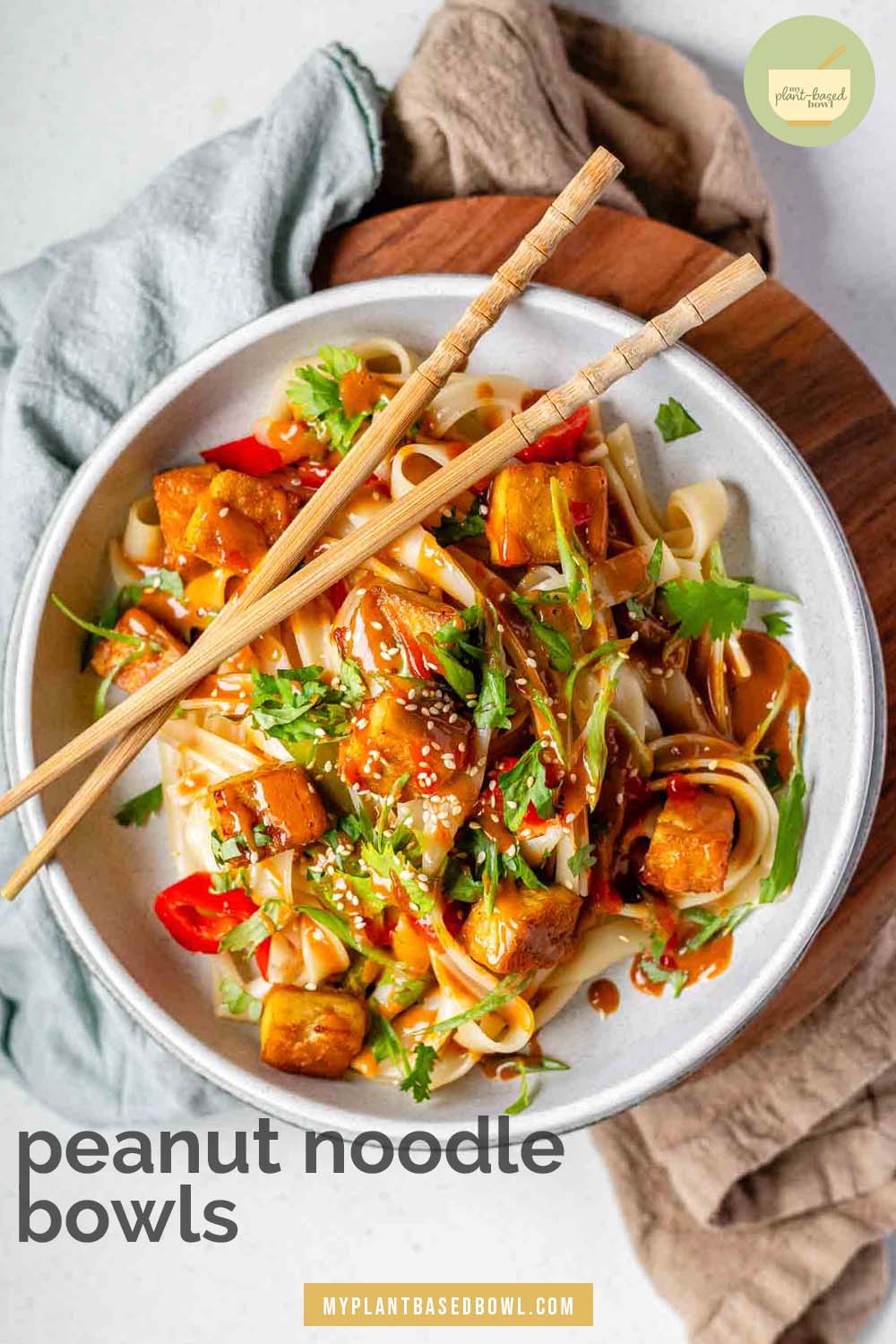 Spicy Peanut Tofu Bowl with rice noodles, red peppers, and creamy peanut sauce with chopsticks with the text peanut noodle bowls.