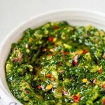 Green chunky sauce in a bowl with the text kale chimichurri.