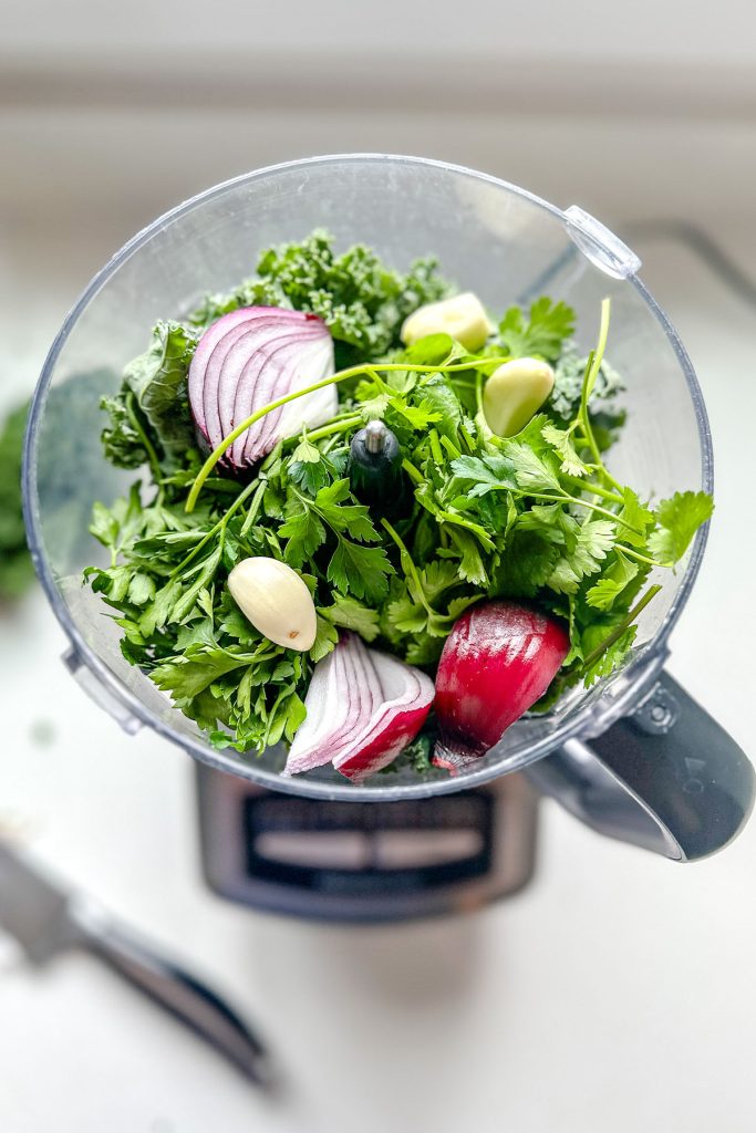Green sauce ingredients in a food processor jar.