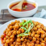 Chickpeas in red sauce in a bowl with the text buffalo chickpeas.