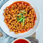 Chickpeas in red sauce in a bowl with the text buffalo chickpeas.
