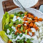 A bowl with rice, chickpeas, salad and a white sauce with the text buffalo chickpea bowls.