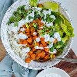 A bowl with rice, chickpeas, salad and a white sauce with the text buffalo chickpea bowls.